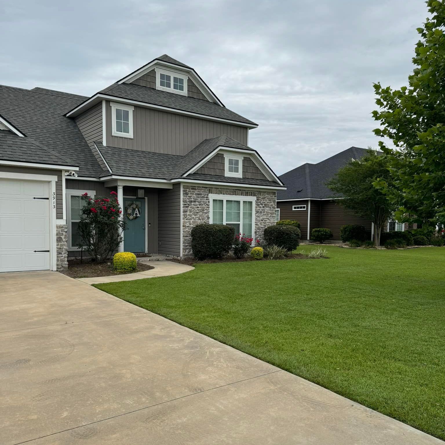 A large house with a gray roof and a white garage door
