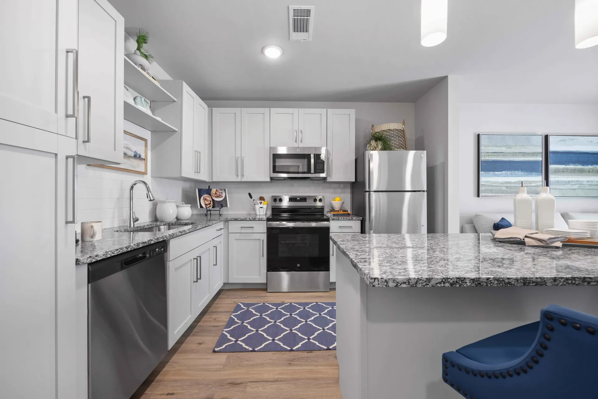 Modern kitchen with white cabinets, stainless steel appliances, and granite countertops.