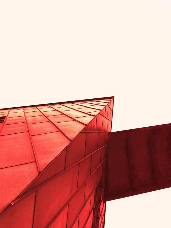 Looking up at a bright red modern building from below