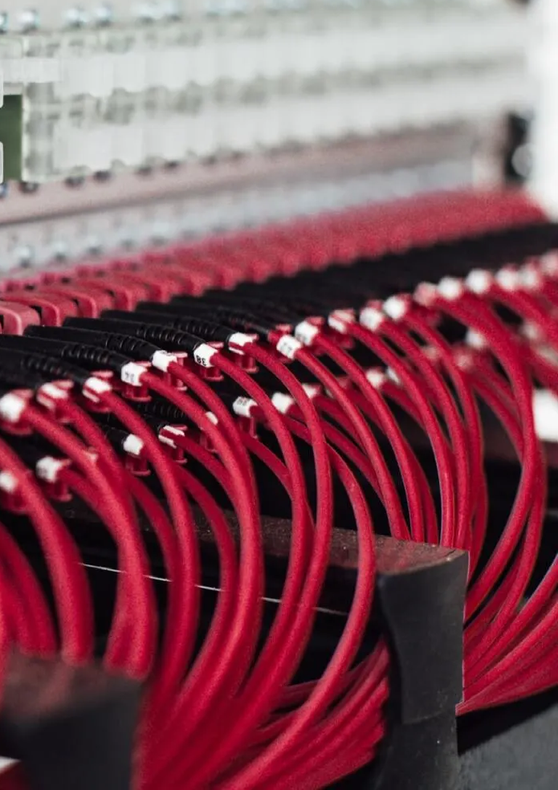 A cluster or red wires attached to a server rack
