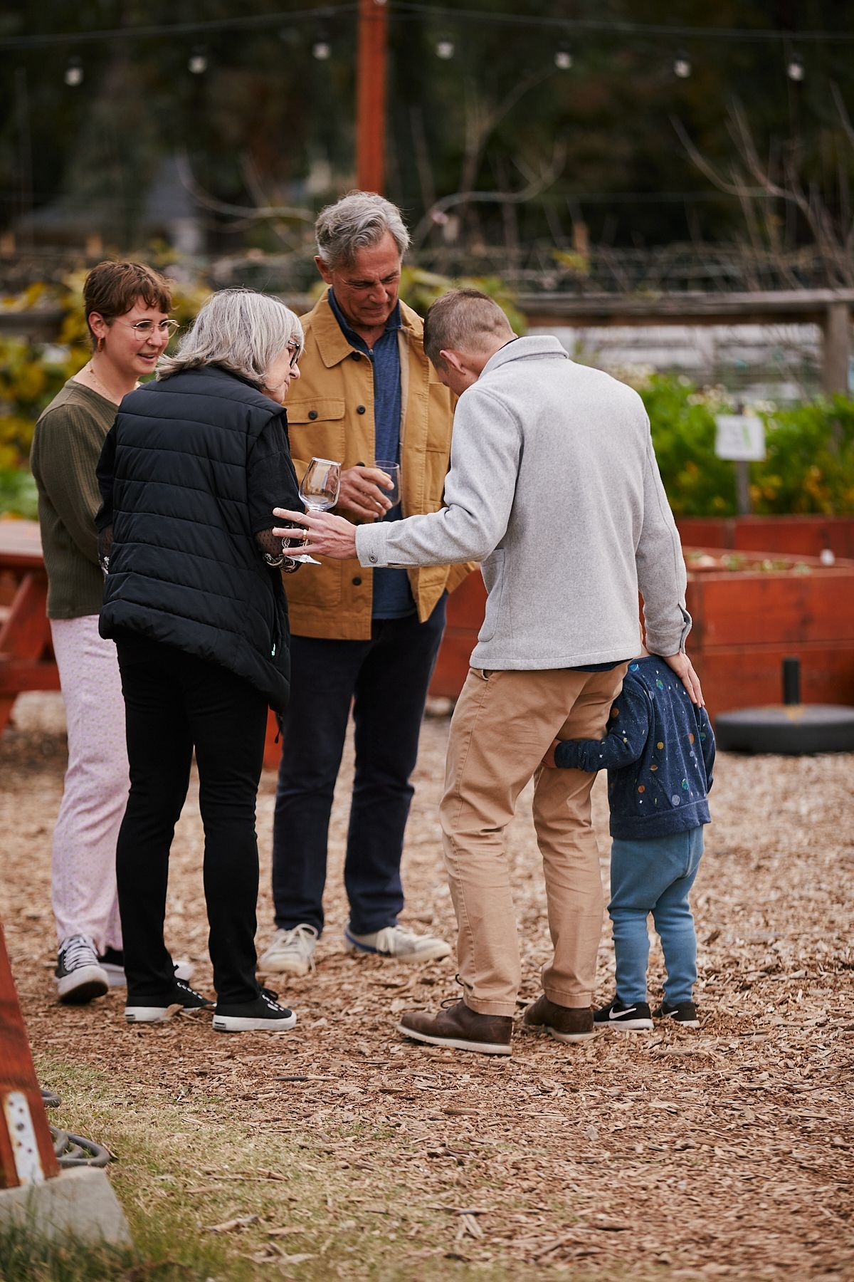 handful of berries above a larger basket of berries with blurry leaves in foreground