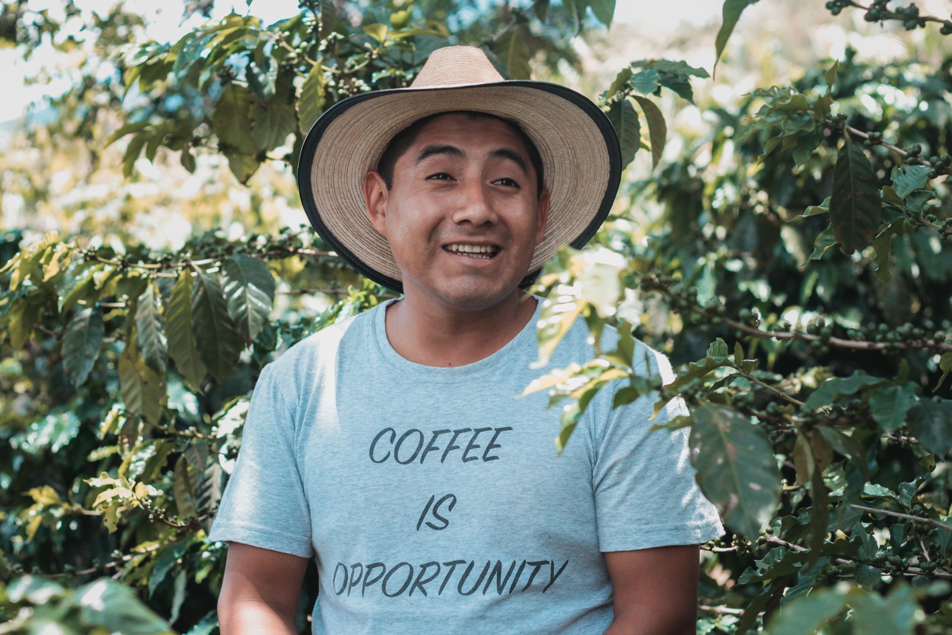 a man wearing a hat and a shirt that says coffee is opportunity