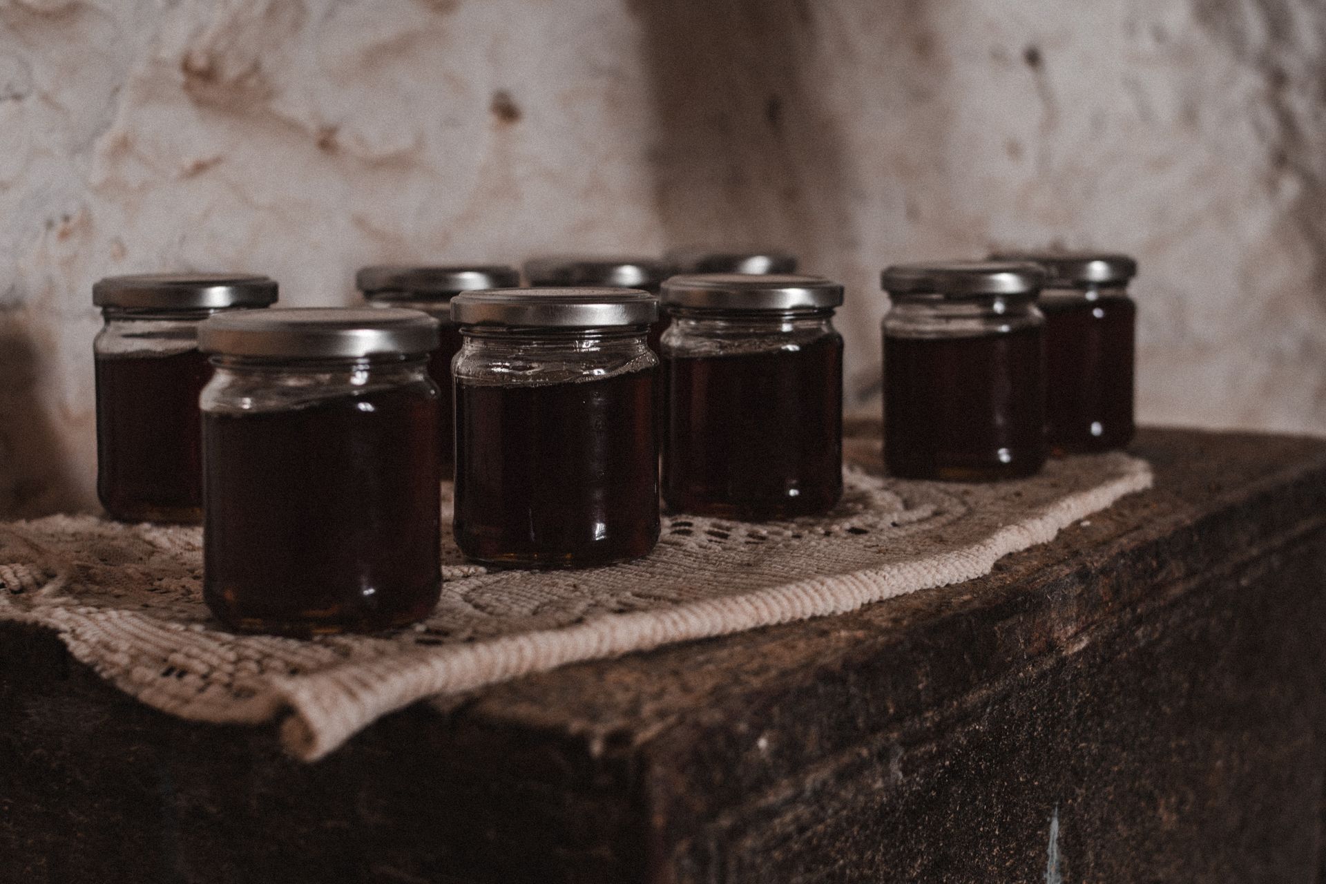 a row of jars filled with dark liquid on a table