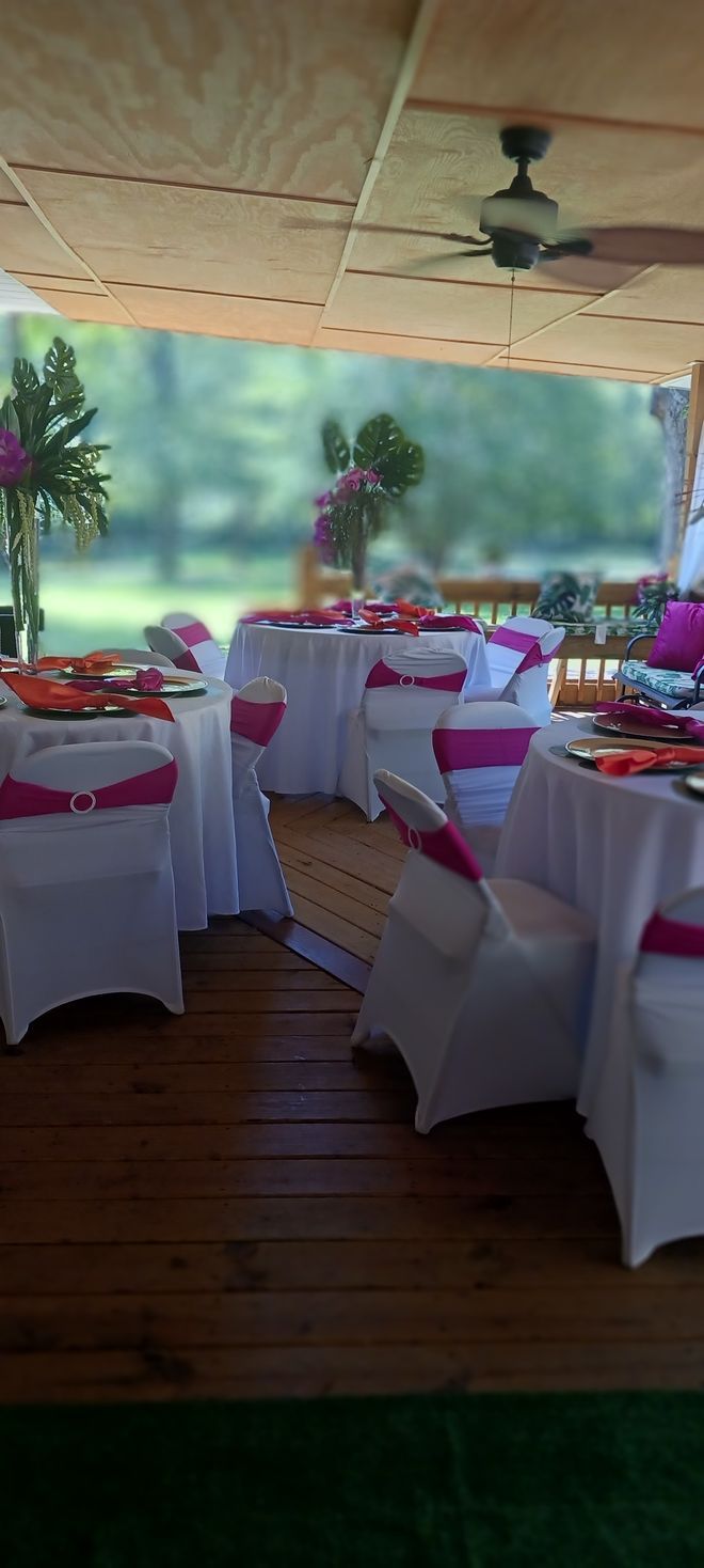 A room with tables and chairs set up for a wedding reception.