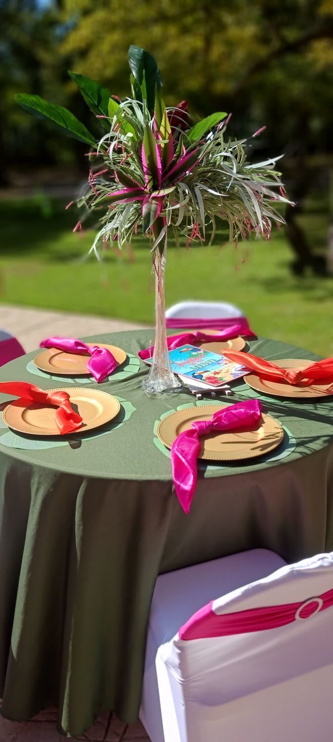 A table with plates , napkins , and a vase of flowers on it.