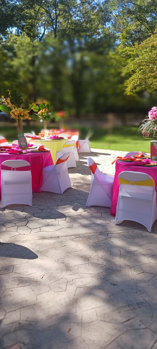 A row of tables and chairs set up for a party on a patio.