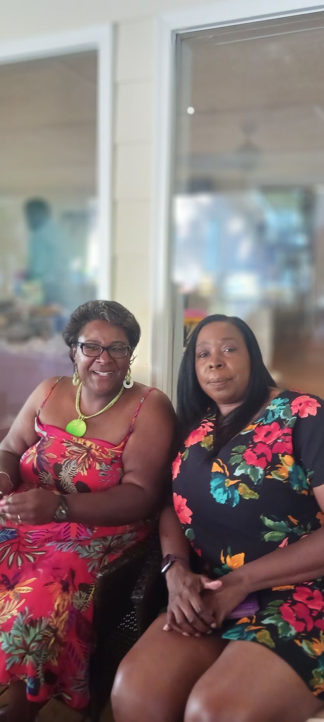 Two women are sitting next to each other in a room.