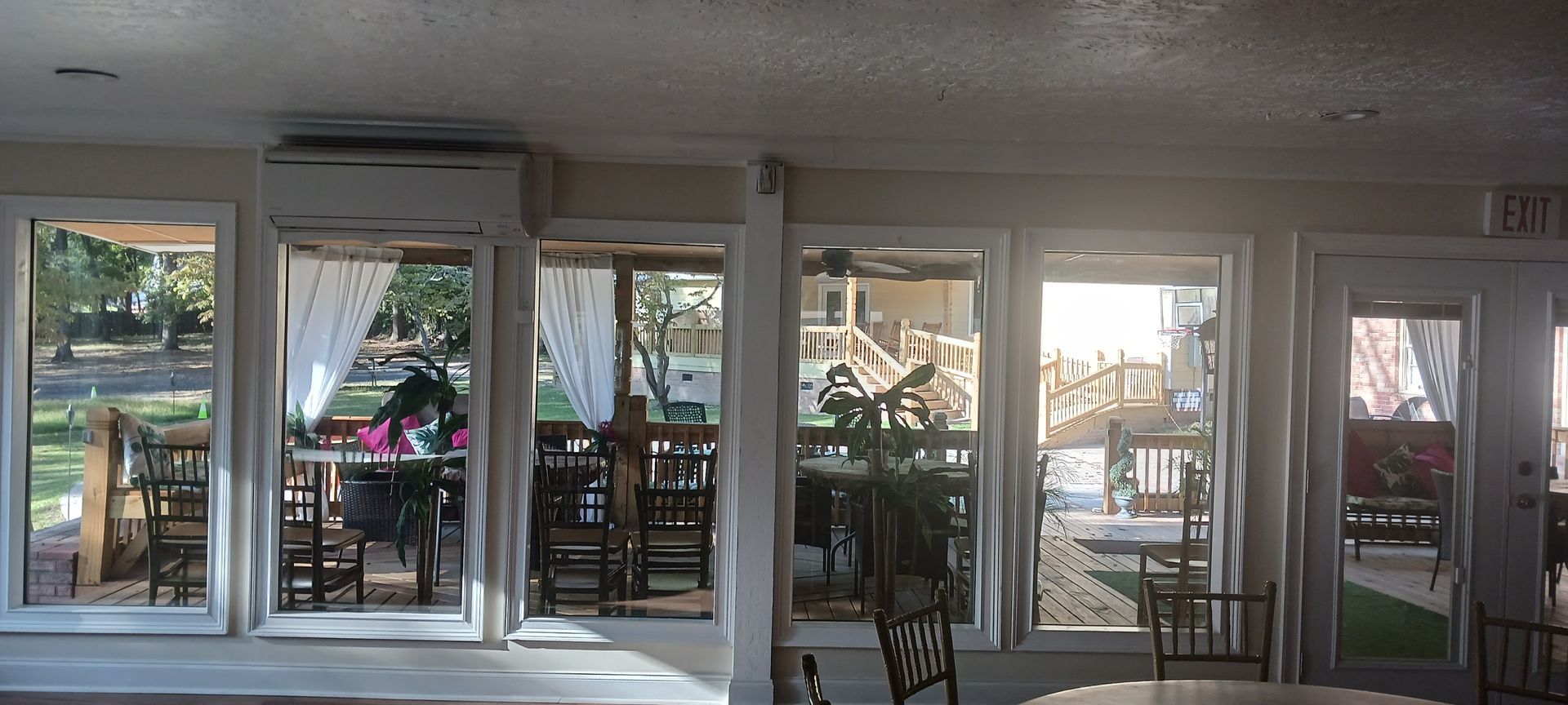 A room with a lot of windows and tables and chairs