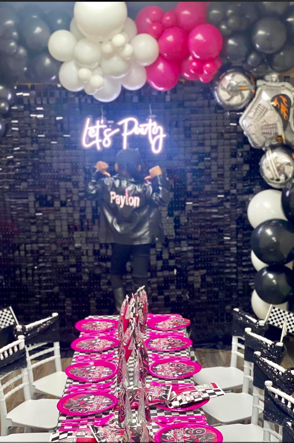 A woman is standing in front of a neon sign that says let 's party.