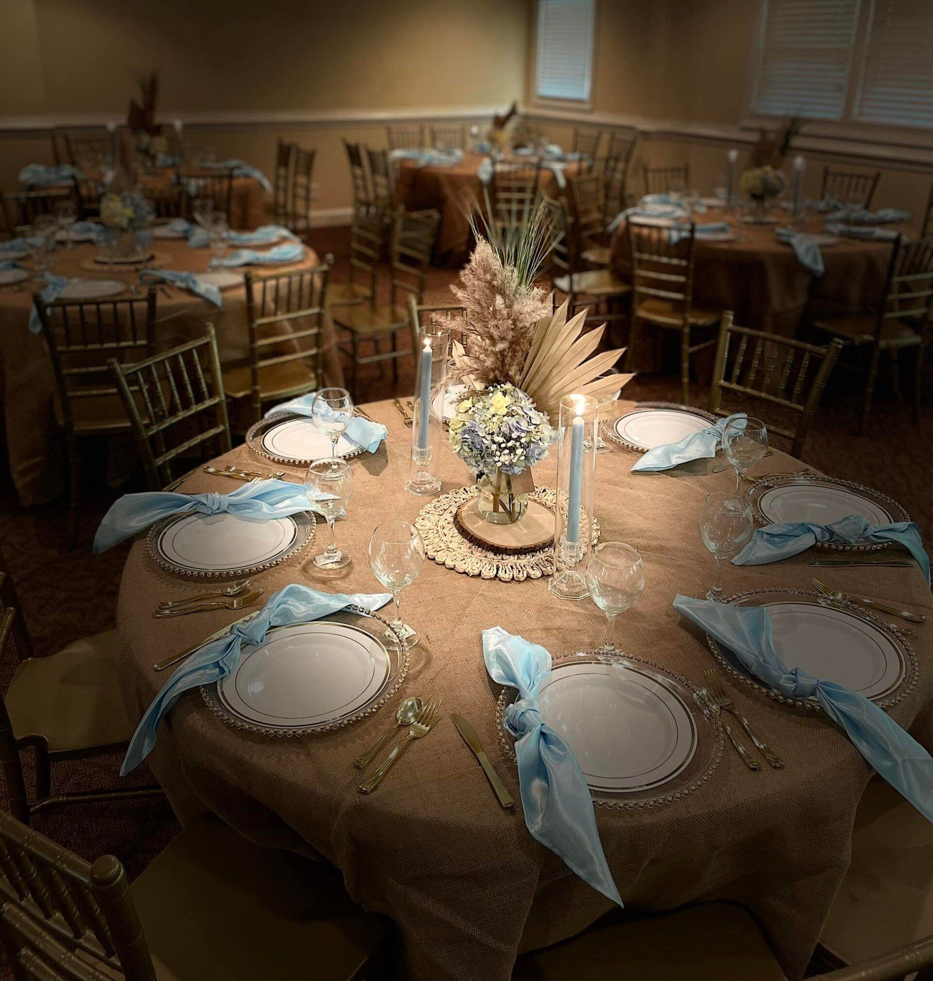 A dining room with tables and chairs set for a wedding reception.