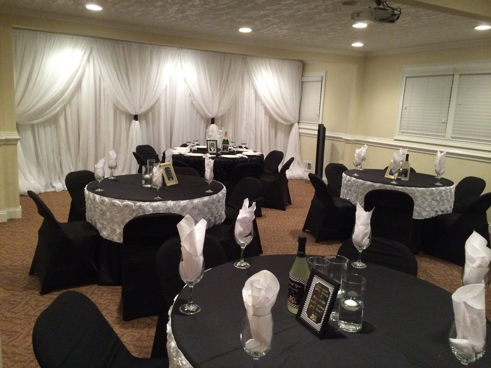 A room with tables and chairs set up for a wedding reception