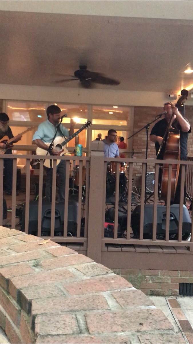 A group of people are playing instruments on a porch.