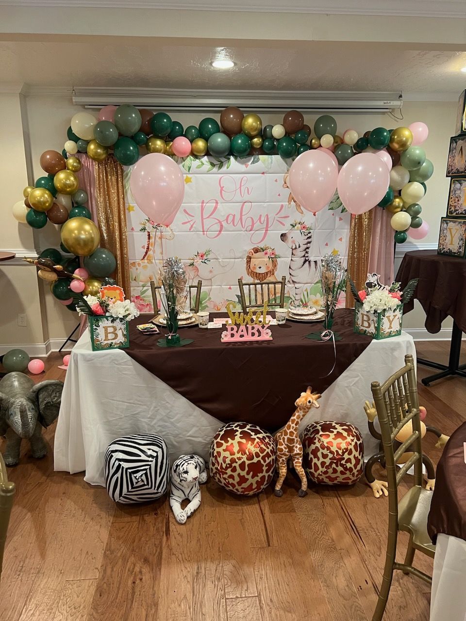 A table decorated with balloons and giraffe pillows for a baby shower.
