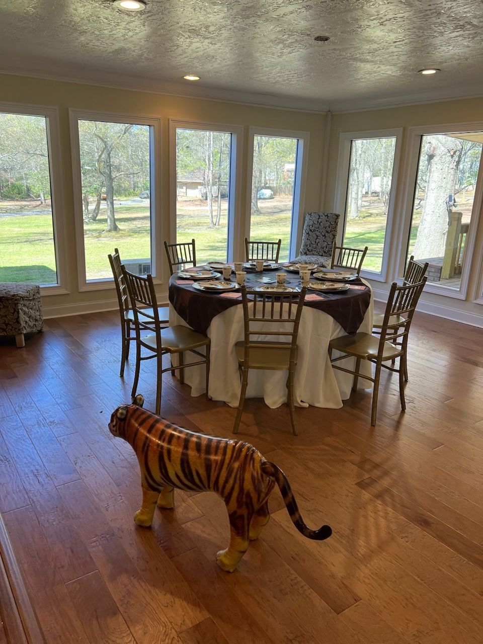 A statue of a tiger is standing next to a table set for a party.