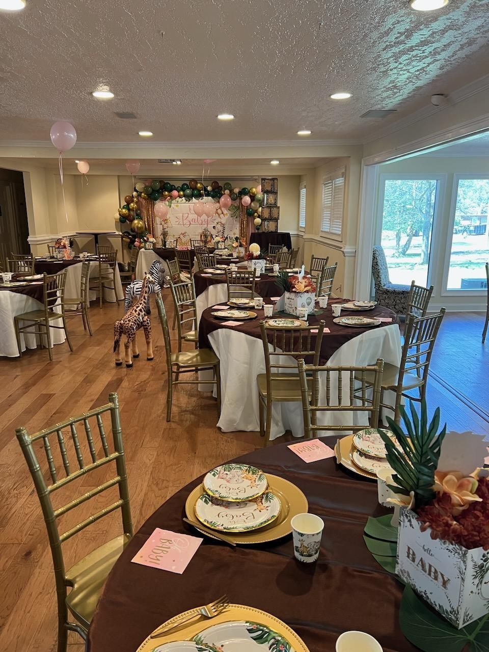 A room filled with tables and chairs set up for a baby shower.