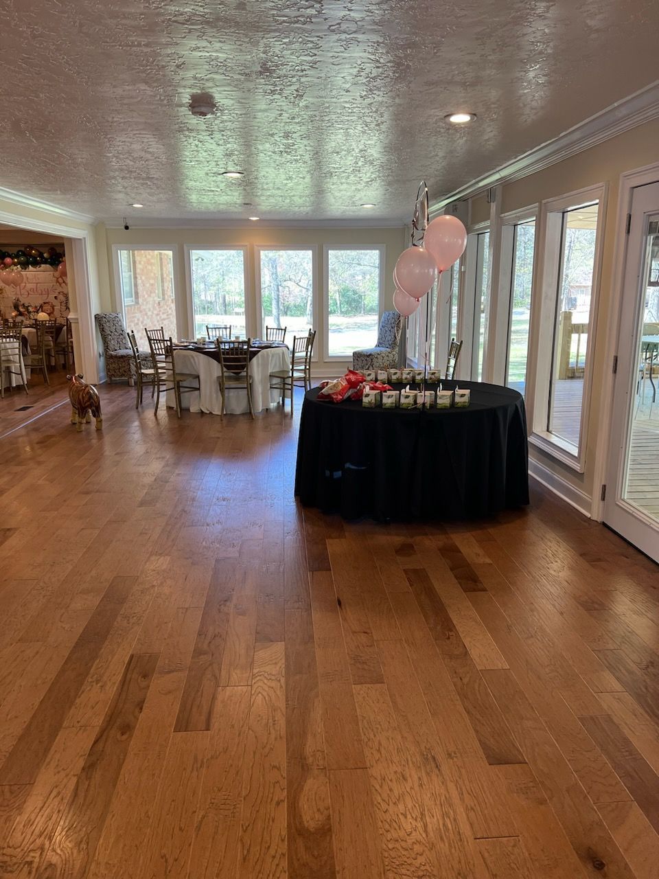 A large room with hardwood floors and a table with candles on it.