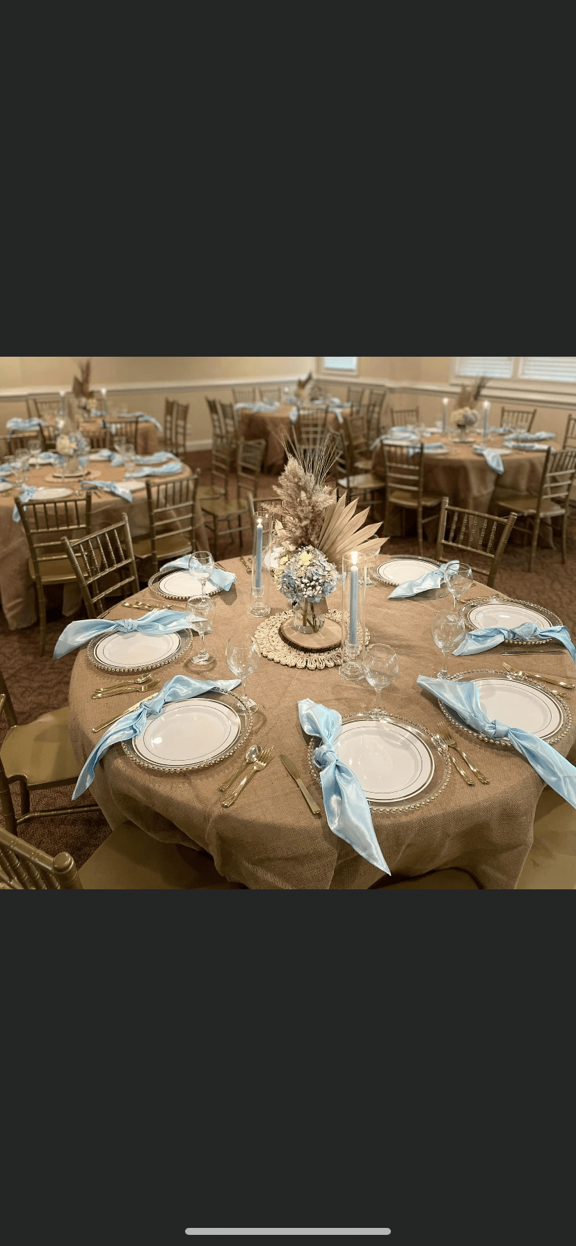 A table set for a wedding reception with plates , napkins , and candles.