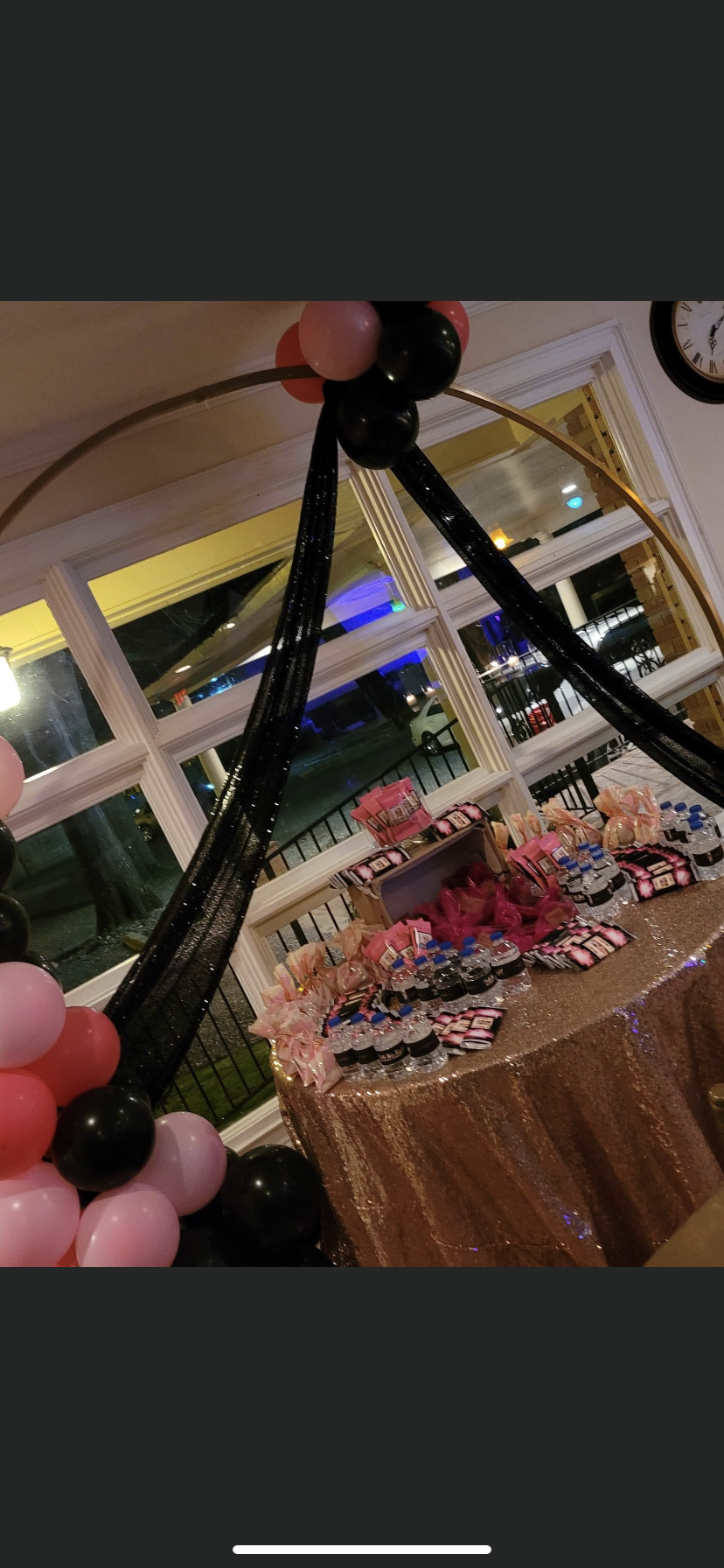 A table with balloons and candy on it in a room.