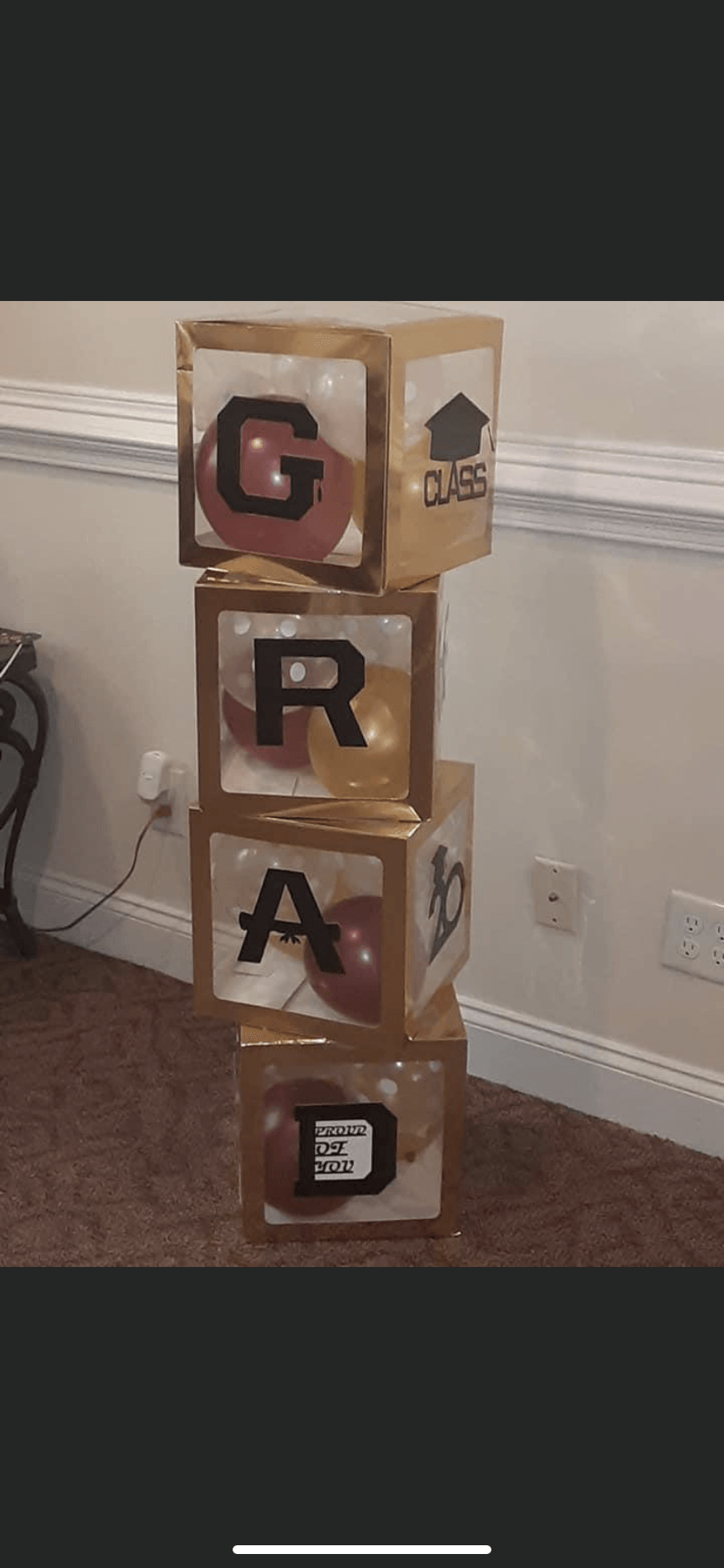 A stack of graduation blocks with balloons inside of them.