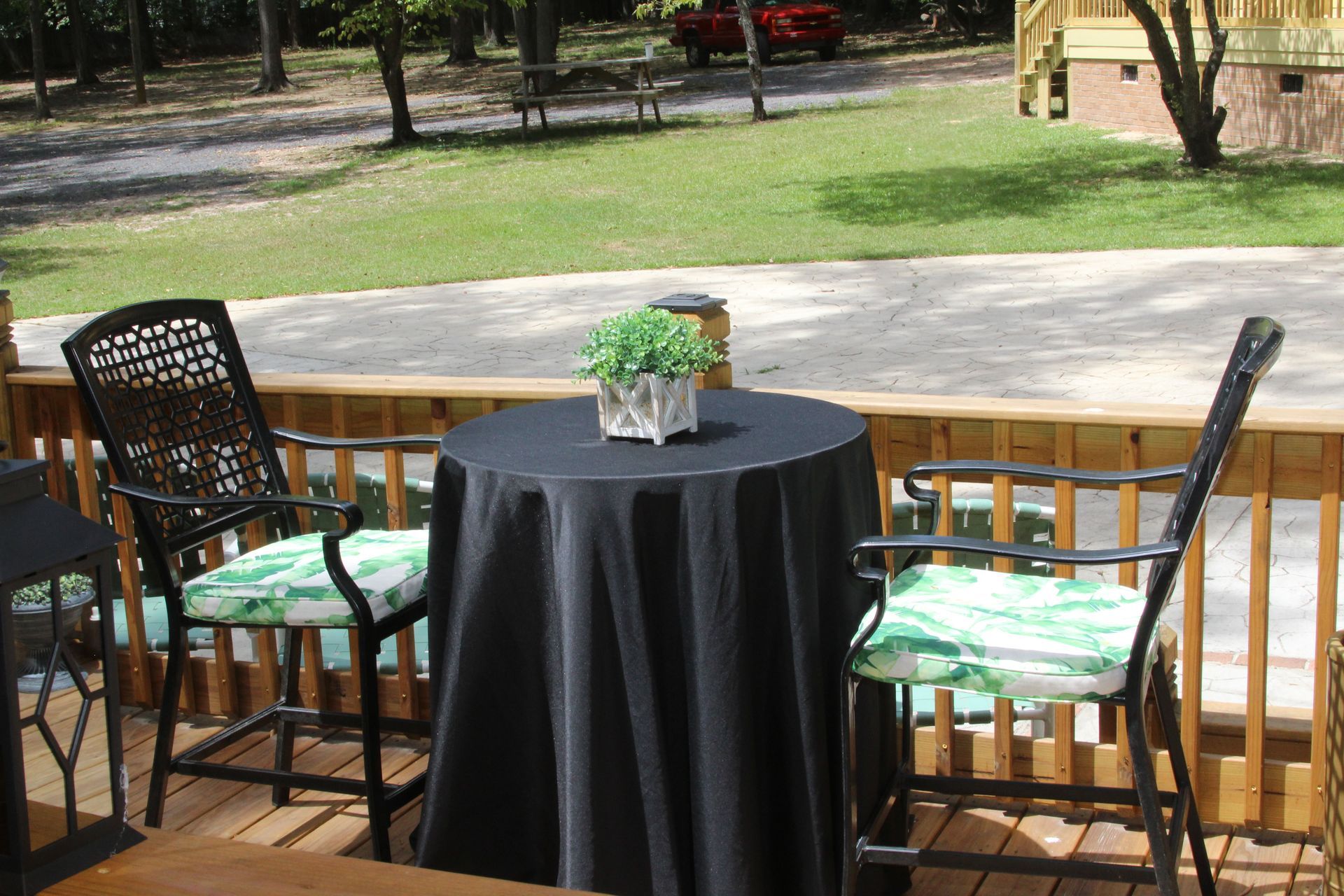 A table and chairs on a deck with a black table cloth