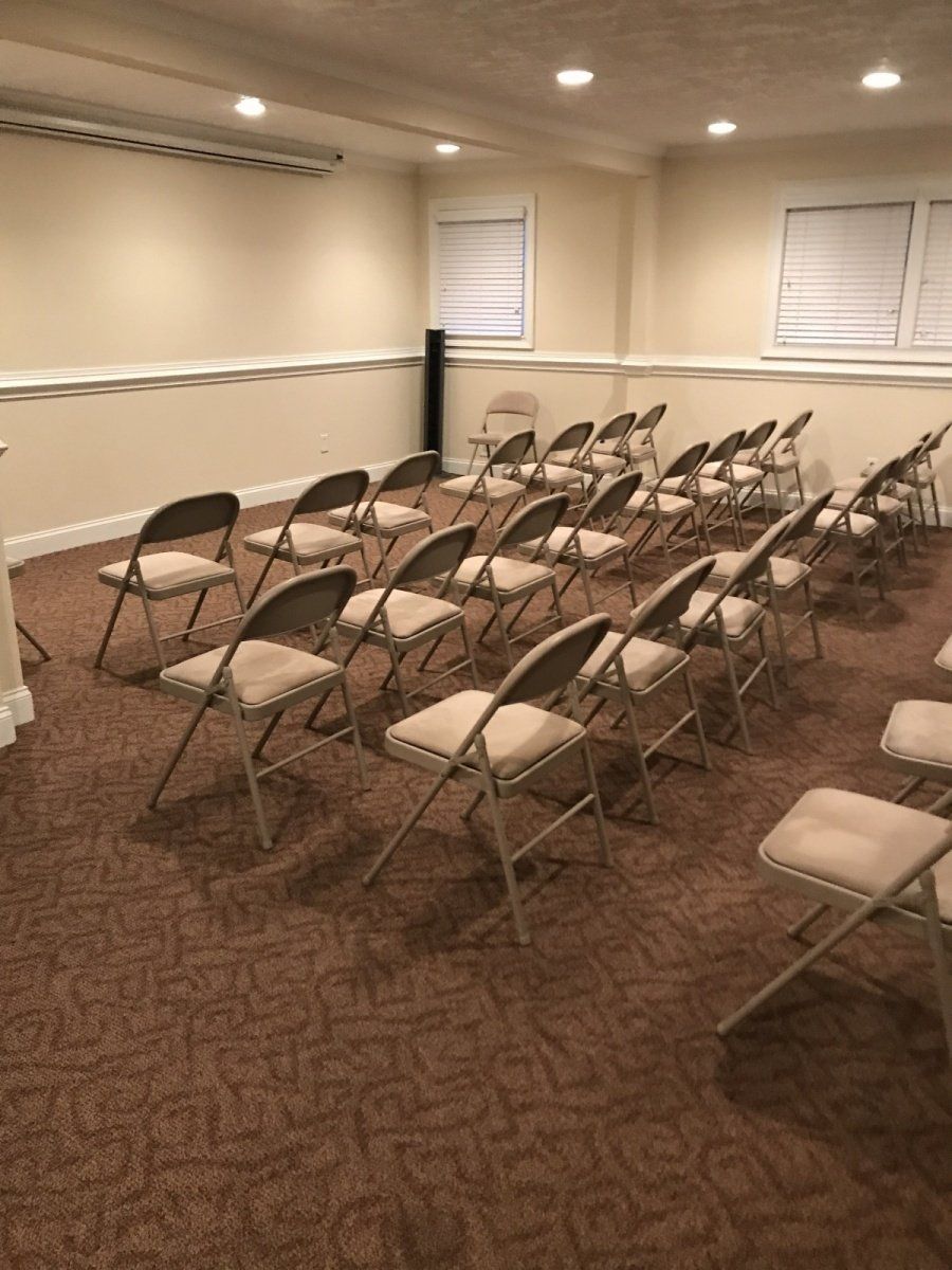 Rows of folding chairs are lined up in a room.