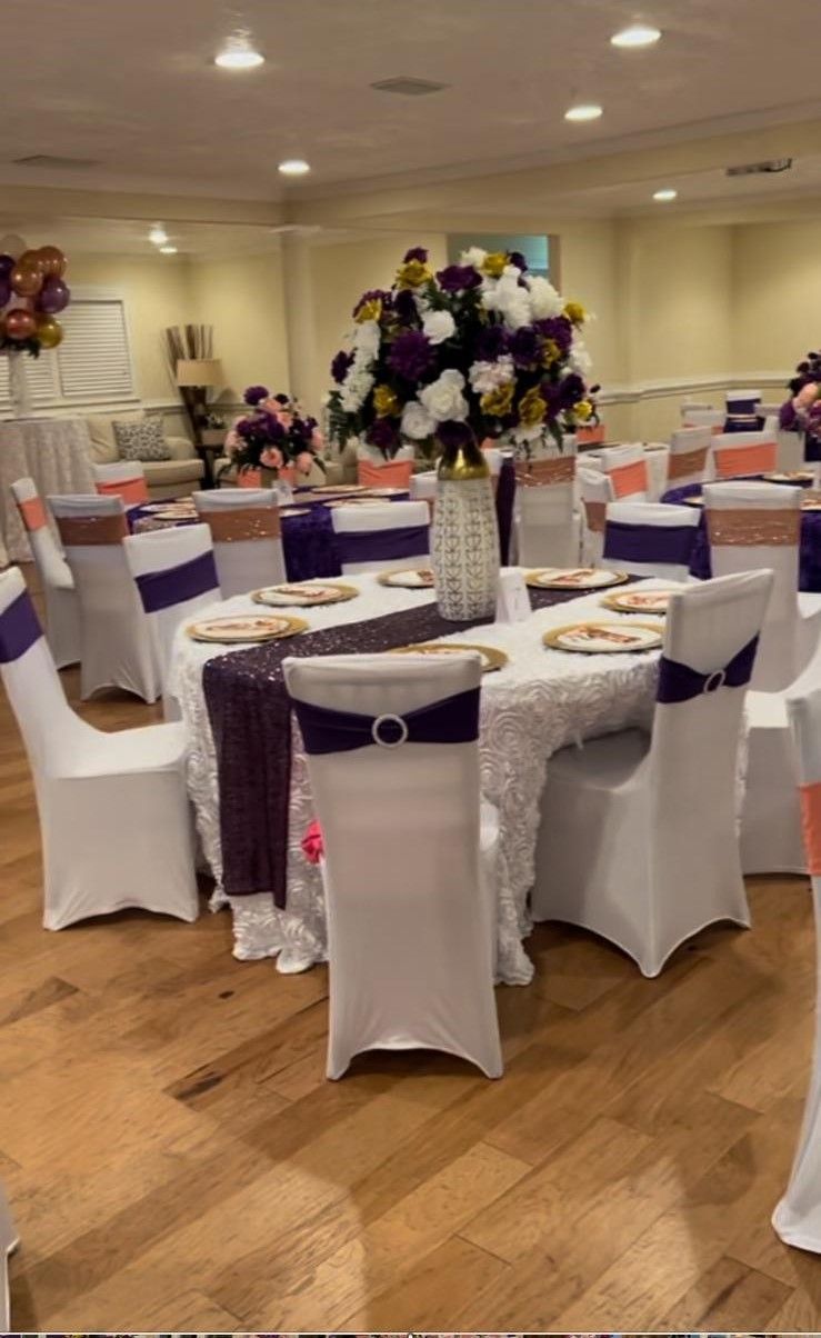 A room with tables and chairs set up for a wedding reception.