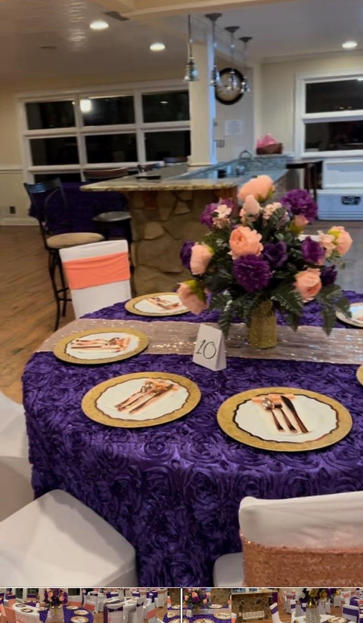 A table with plates and utensils on it and a vase of flowers on it.
