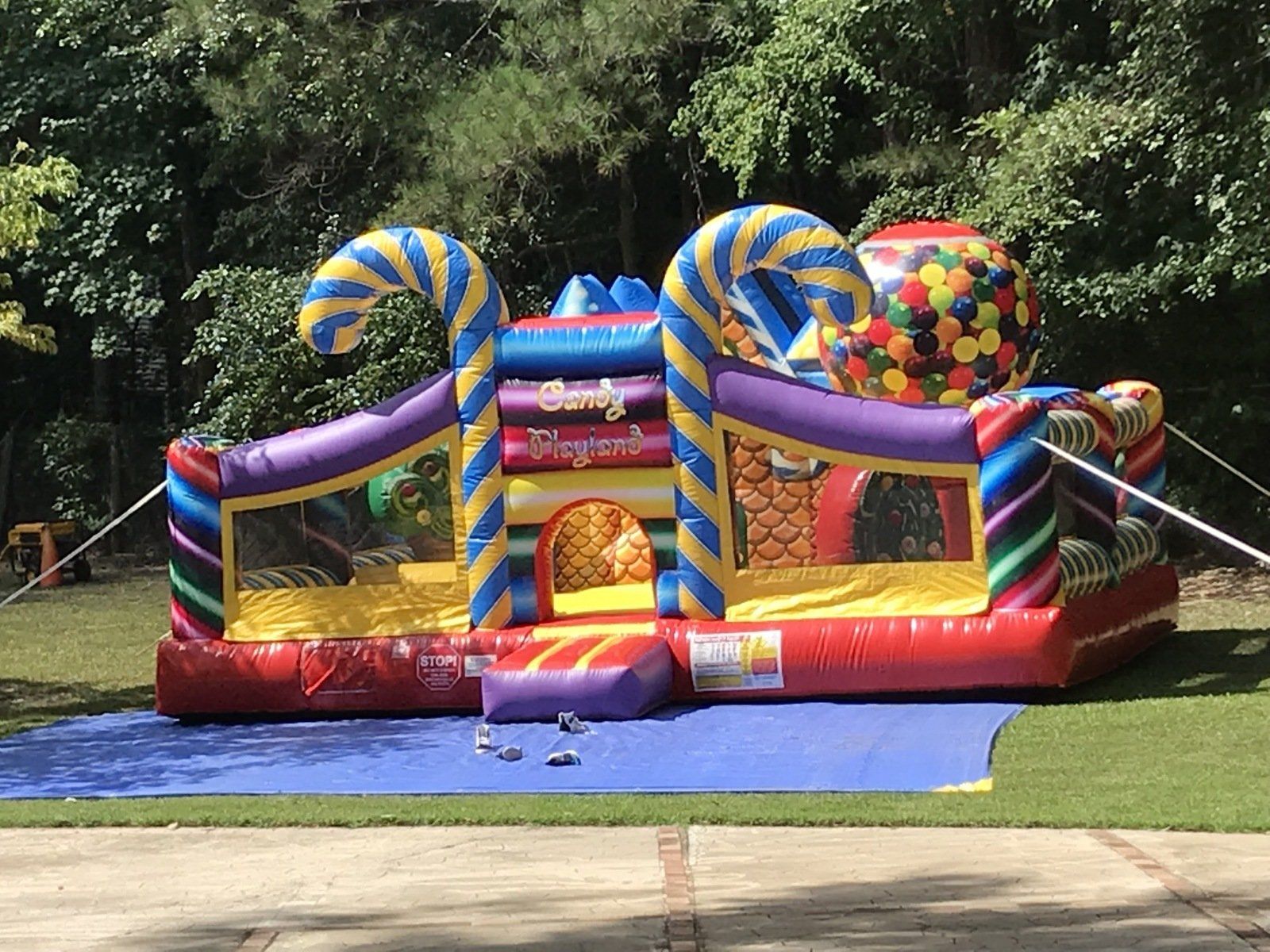 A colorful bouncy house with candy canes and gumballs on top of it.