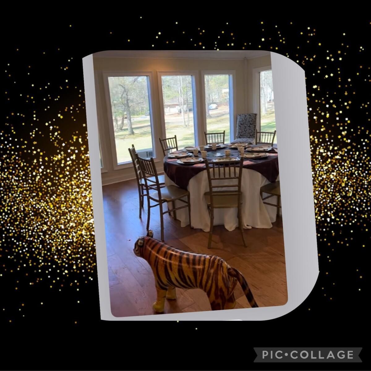 A stuffed tiger is standing in front of a table set for a party.