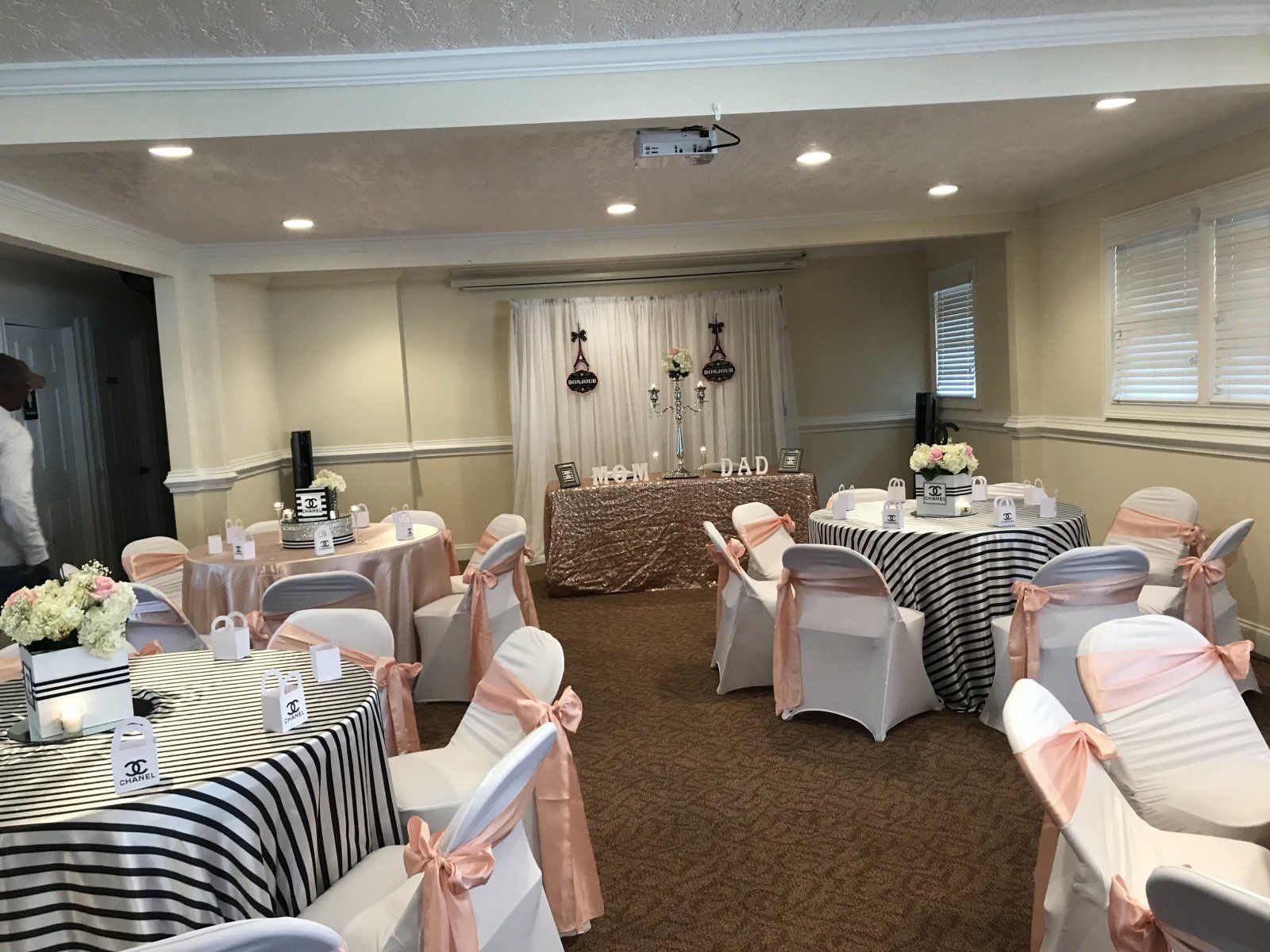 A room with tables and chairs set up for a wedding reception