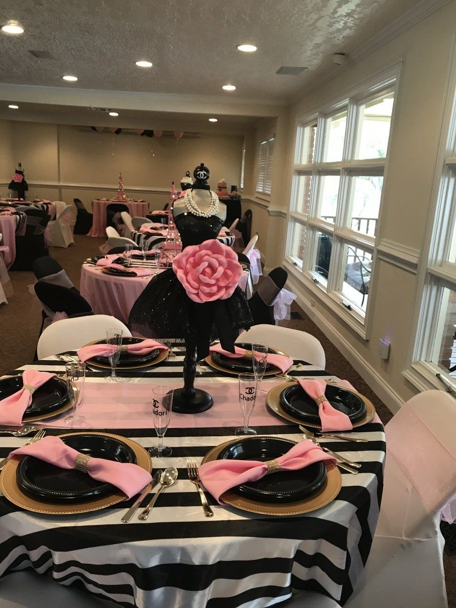 A black and white striped table cloth is on a table with plates and napkins.