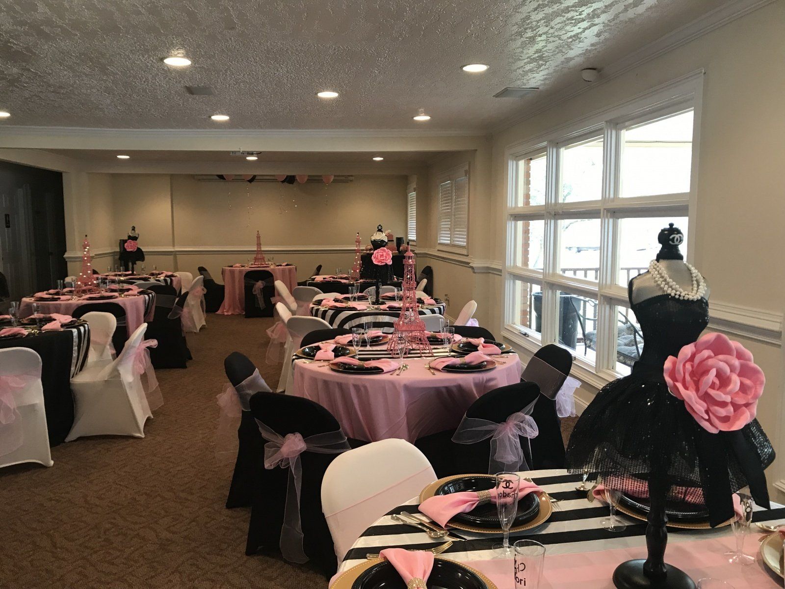 A large room with tables and chairs set up for a party.