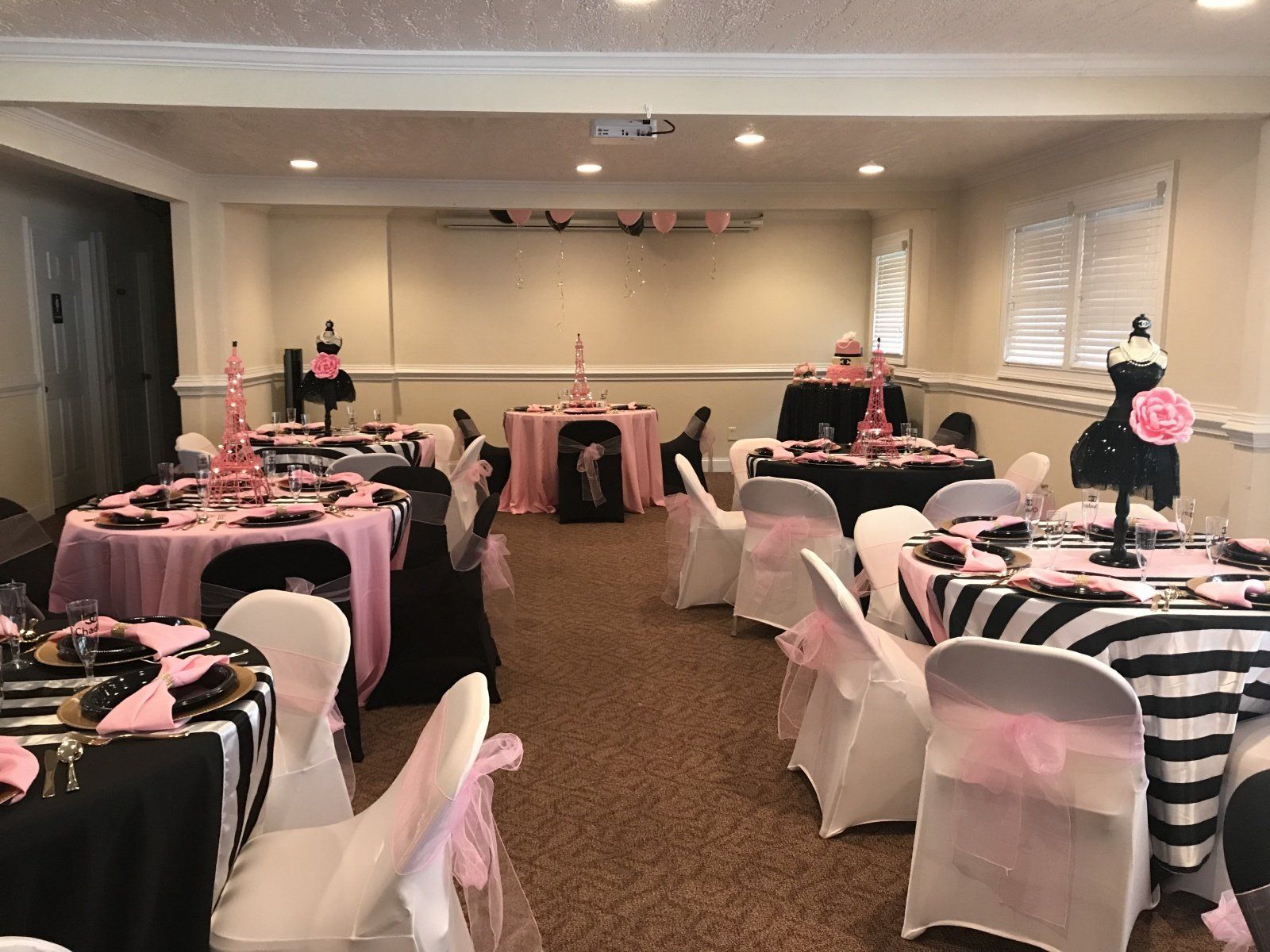 A room with tables and chairs set up for a party.