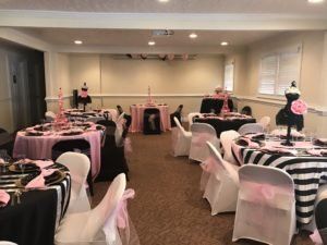 A room with tables and chairs set up for a party.
