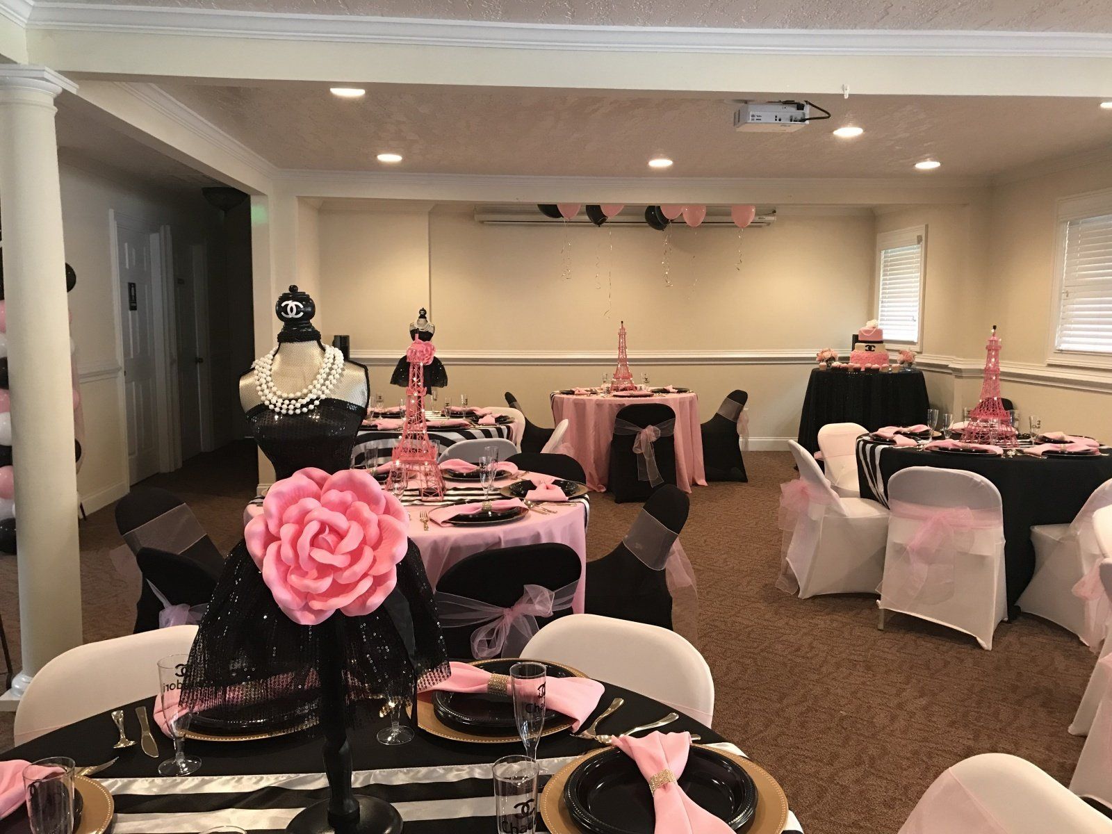 A room with tables and chairs set up for a party.