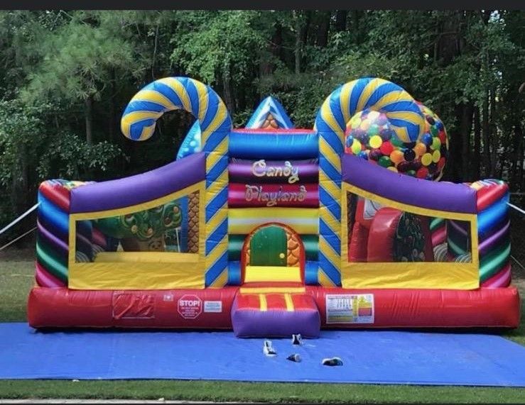 A colorful bouncy house with candy canes on top of it