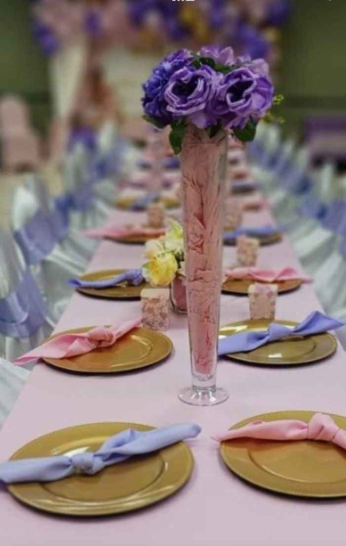 A long table with plates and flowers on it