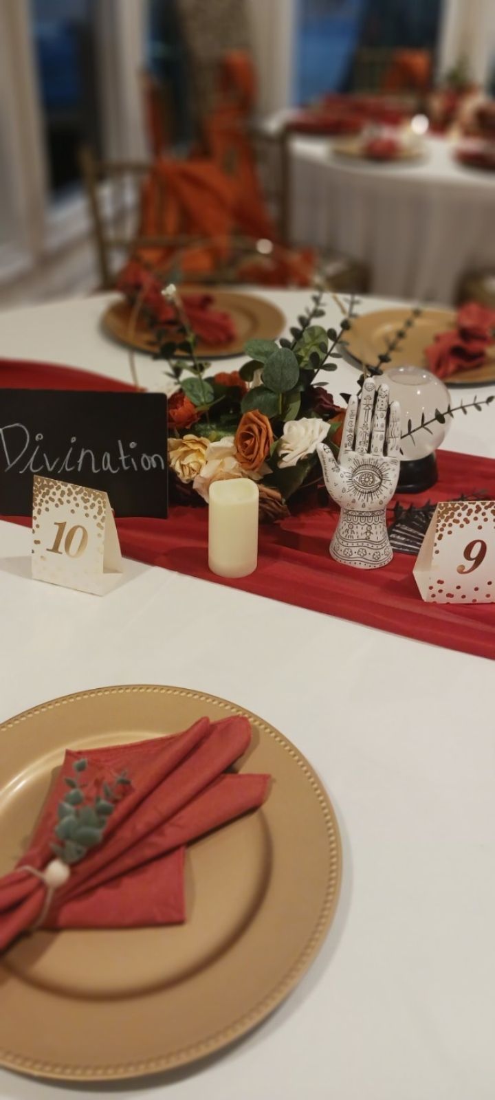 A table set for a wedding reception with plates , napkins , candles and flowers.