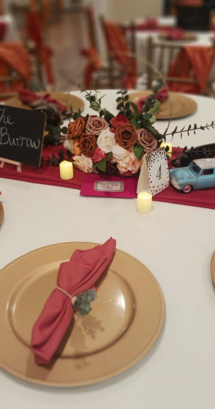 A table with plates , napkins , candles and flowers on it.