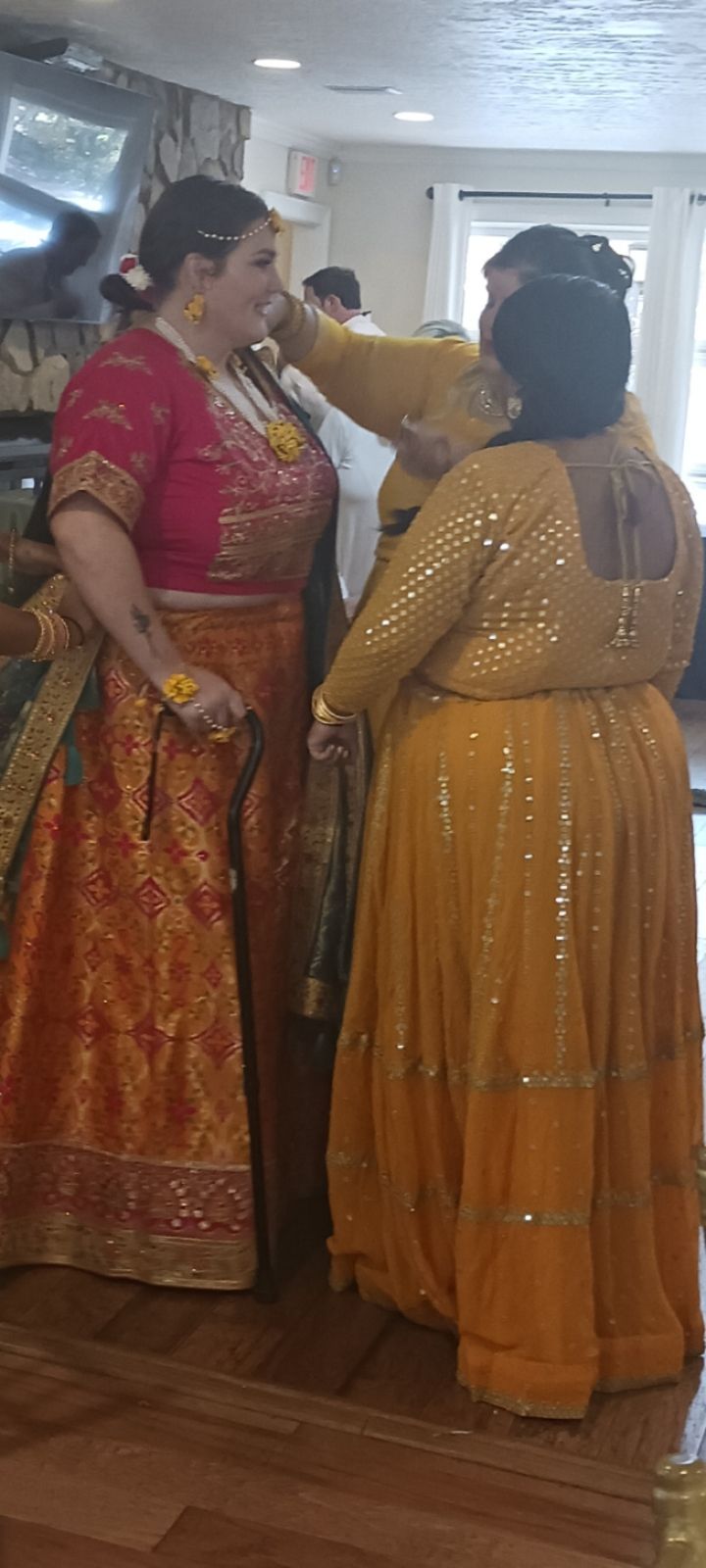 Two women in traditional indian dresses are standing next to each other in a room.