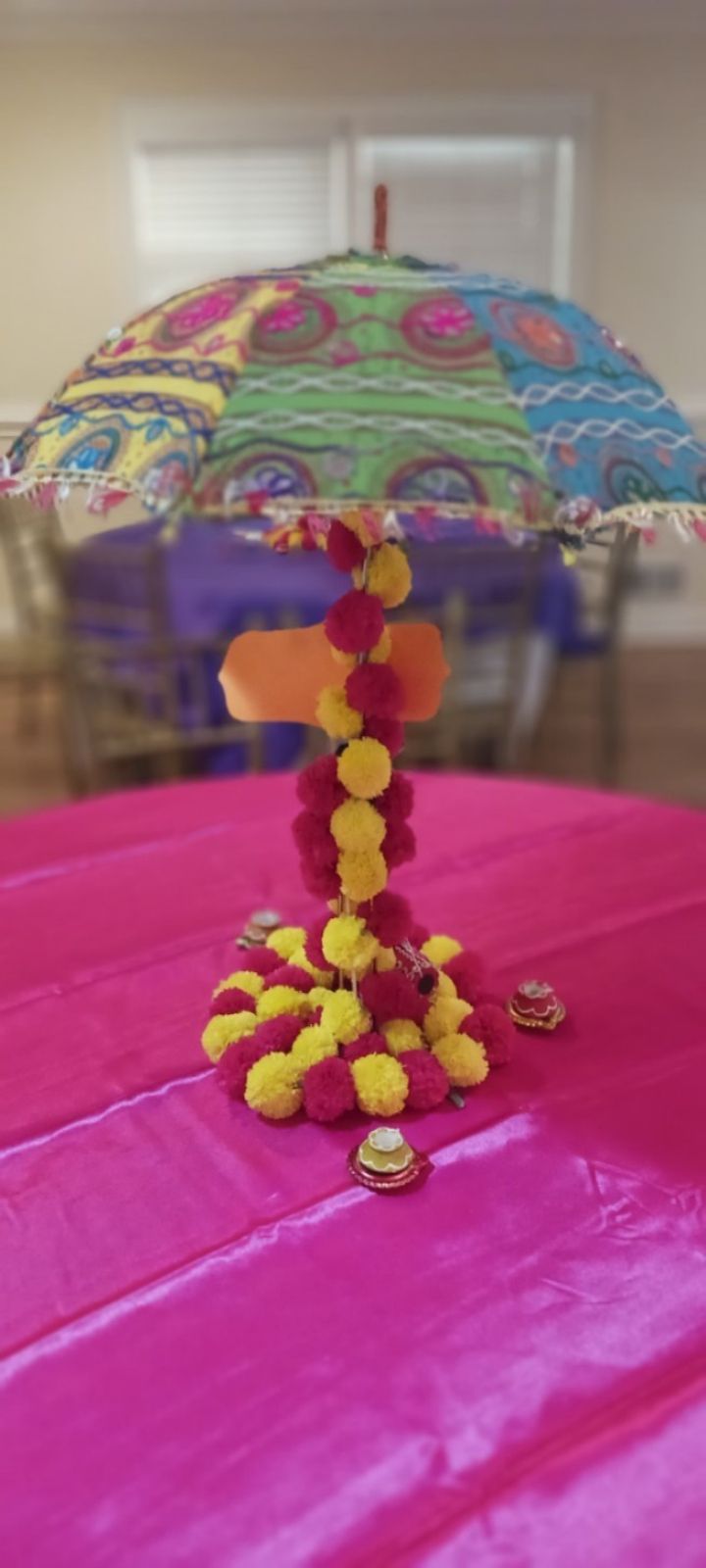 A table with a vase of flowers and candles on it.