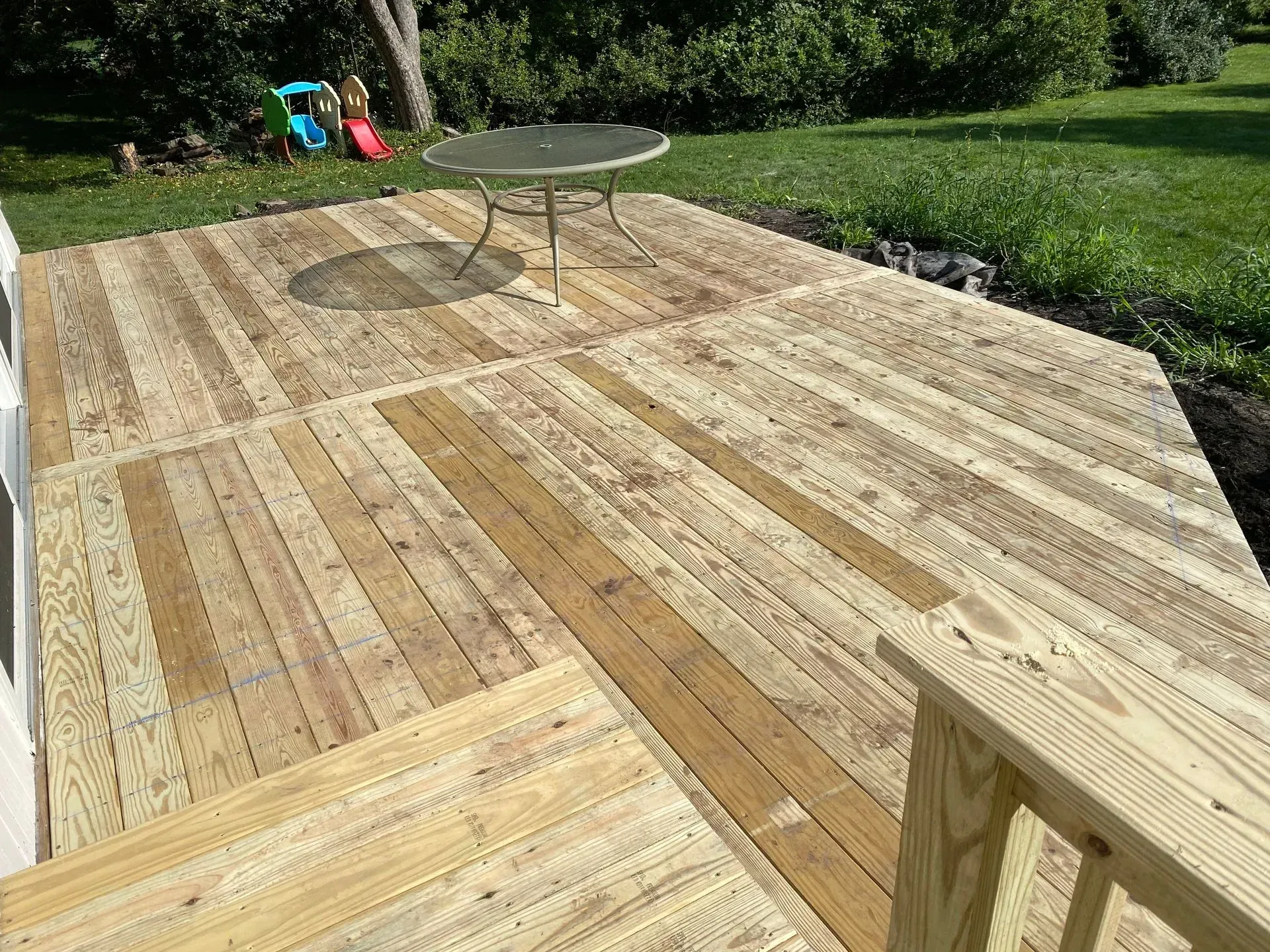 A wooden deck with a table and chairs on it.