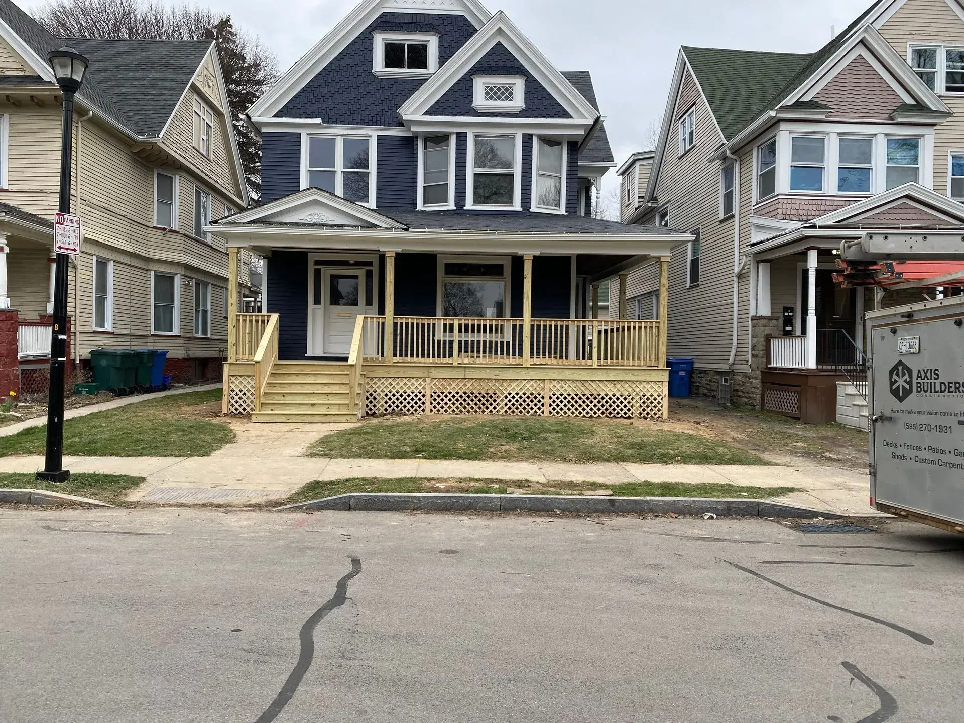 A blue house with a wooden deck in front of it