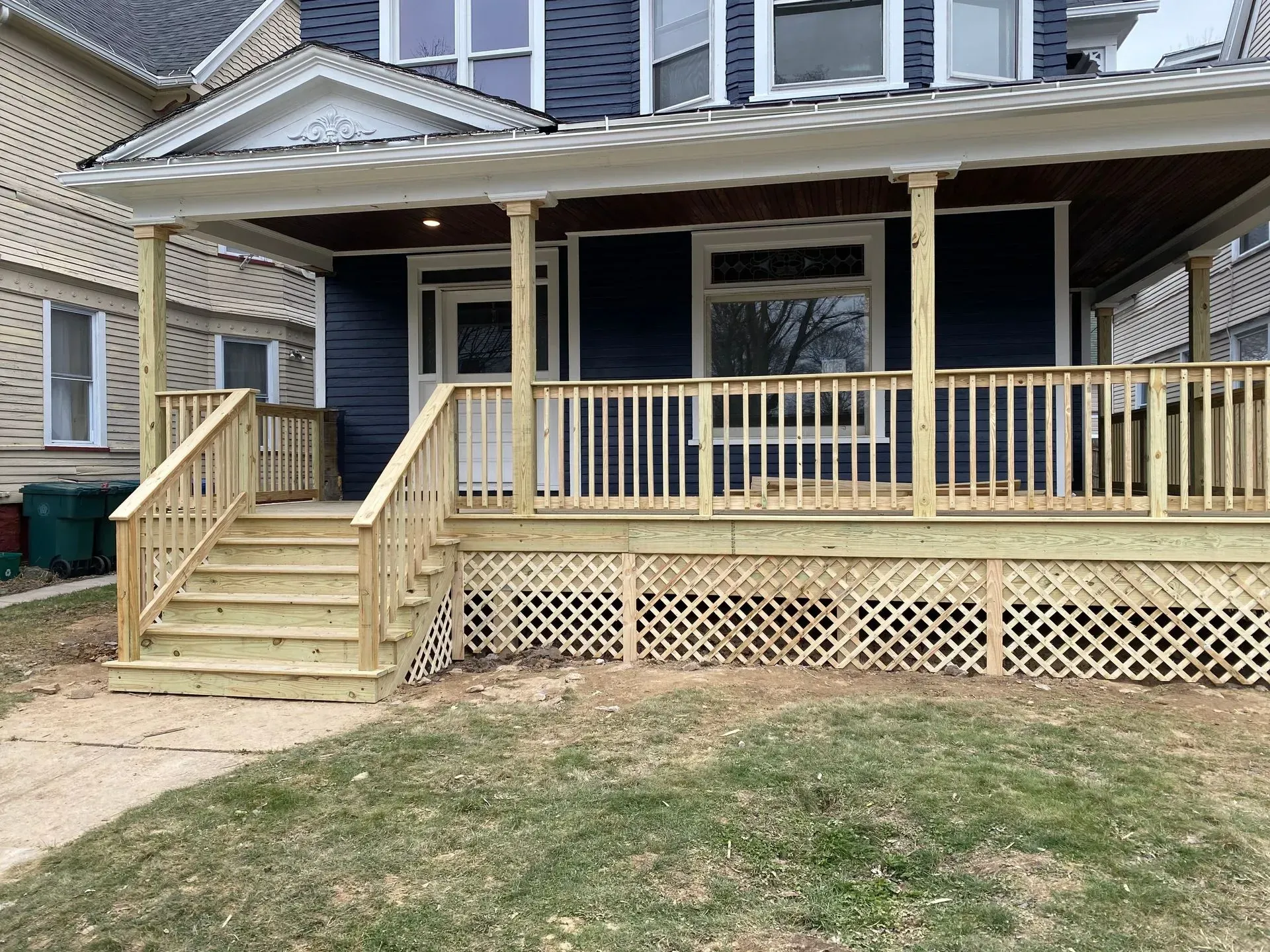 A blue house with a wooden porch and stairs.