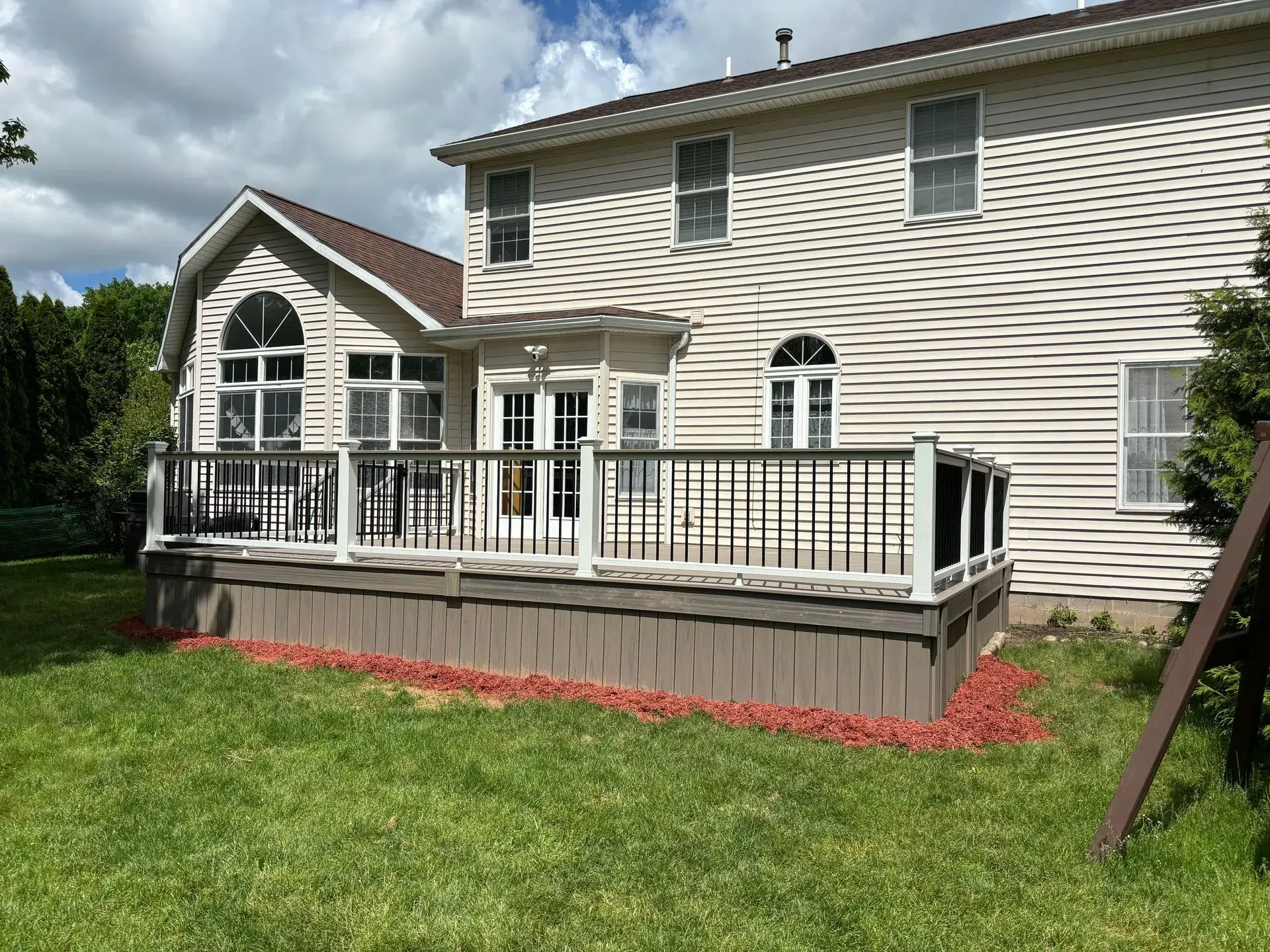 A large white house with a large deck in front of it.