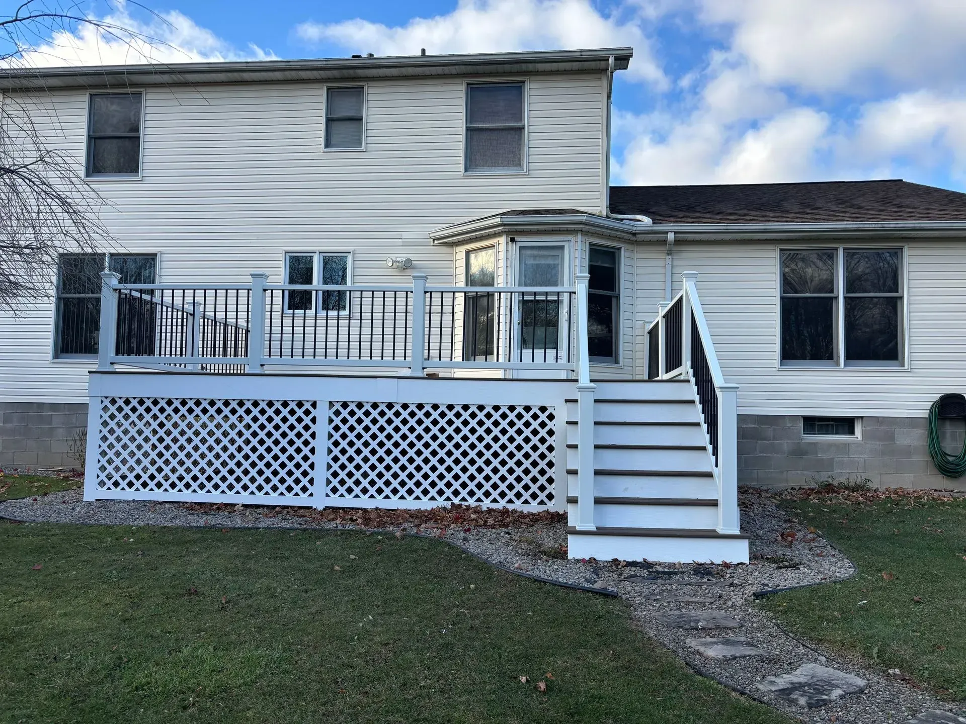 A white house with a white deck and stairs