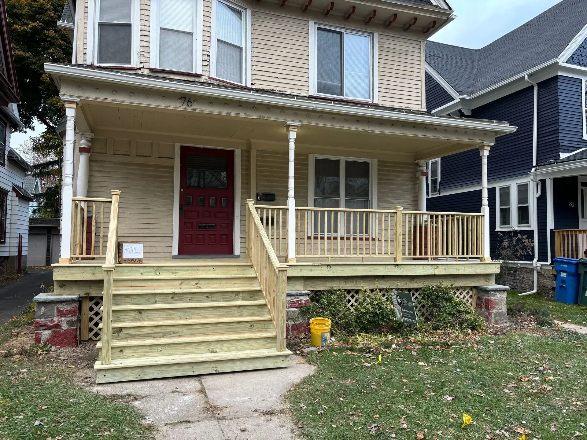 A house with a wooden porch and stairs in front of it.