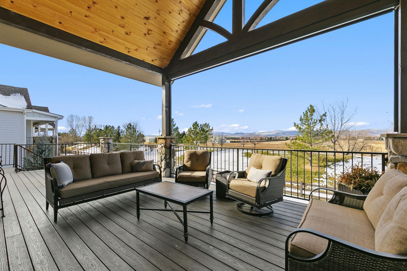 A deck with a couch , chairs , and a table
