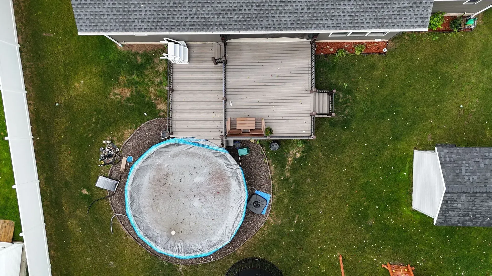 An aerial view of a backyard with a pool and a deck.
