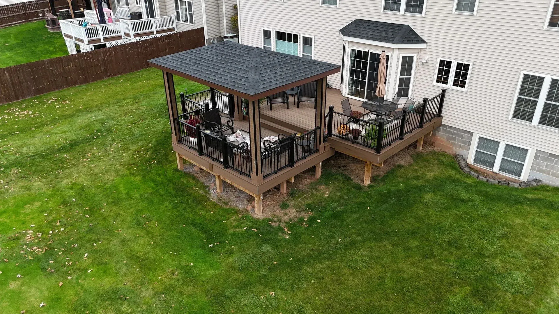 An aerial view of a large deck with a gazebo in the backyard of a house.